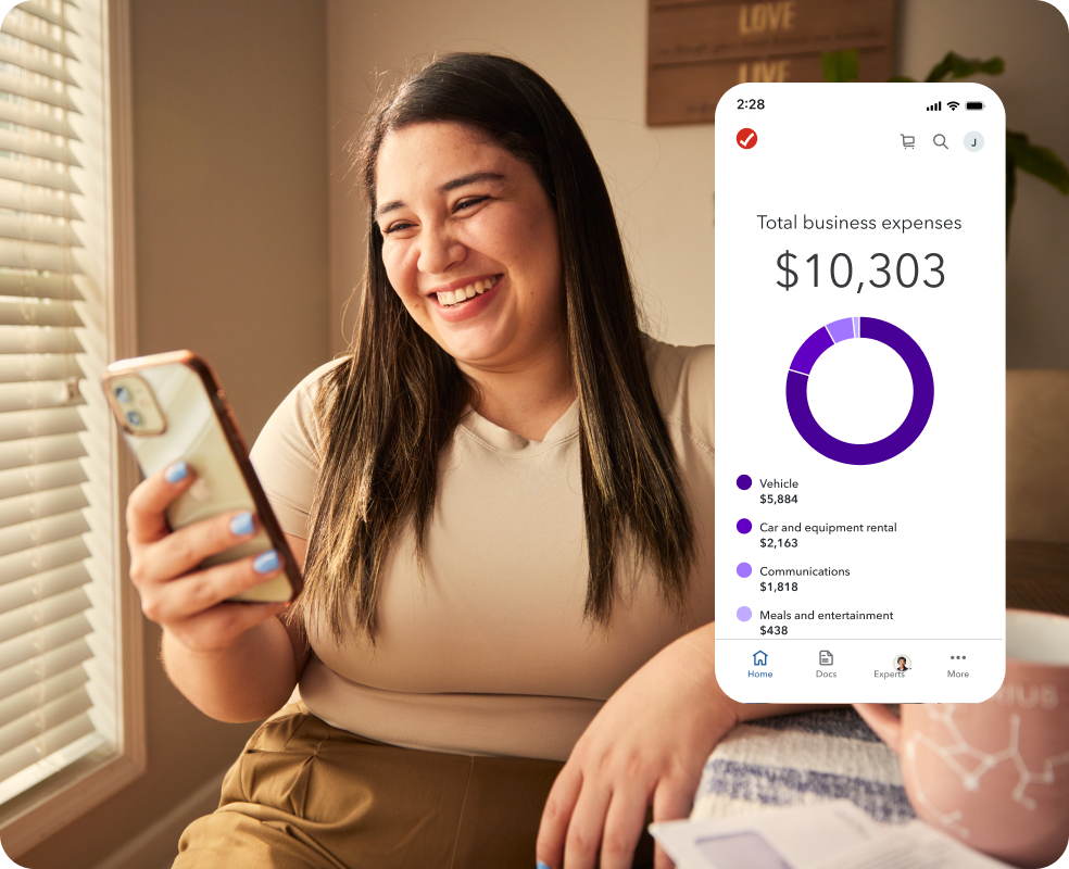 TurboTax customer Vanessa smiles as she looks down at her phone in her hands.
