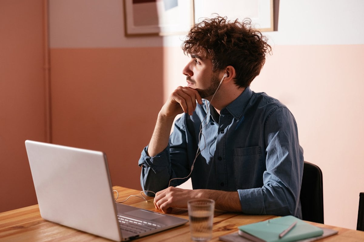A person sitting at a table with a laptop.