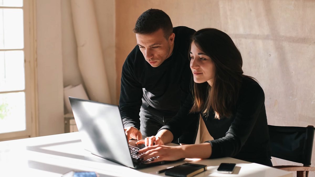 a young couple using a laptop computer